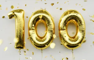"100" spelled out in golden balloons Shutterstock